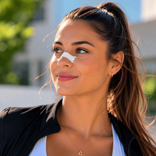 AuraBreath™ – Bandelettes Nasales Respiratoires sur le nez d'une femme souriante en extérieur.
